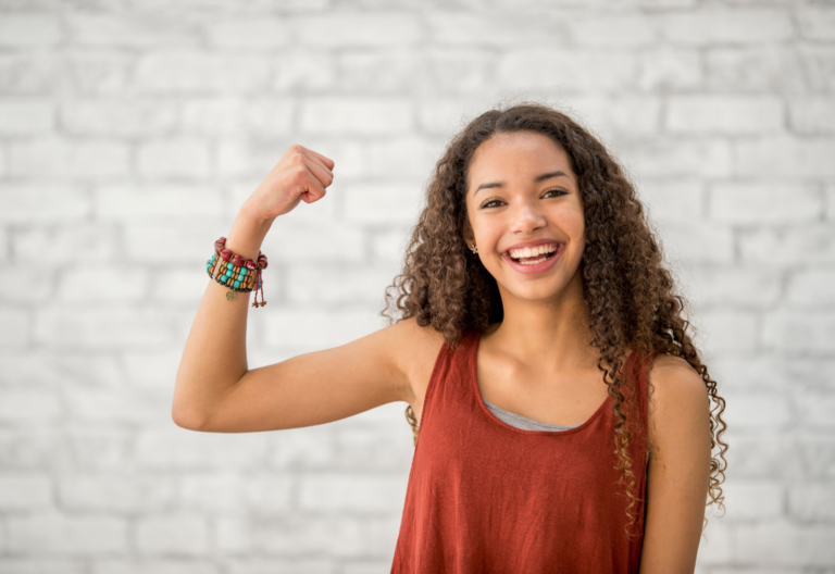 Photo of a smiling person striking the strong pose for International Women's Day 2025 Accelerate Action